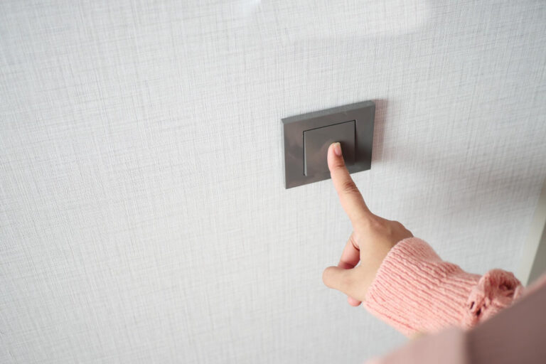 Personne inquiète regardant les interrupteurs électriques de sa maison