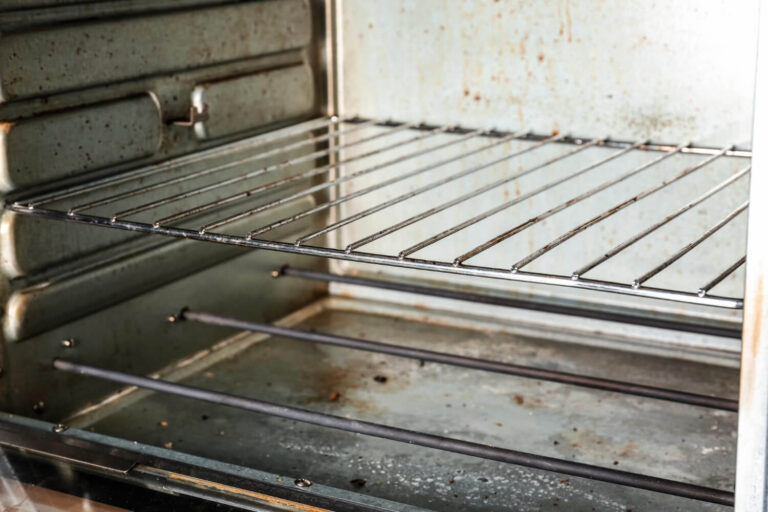 Intérieur d'un four électrique présentant de la rouille sur les parois et les grilles de cuisson