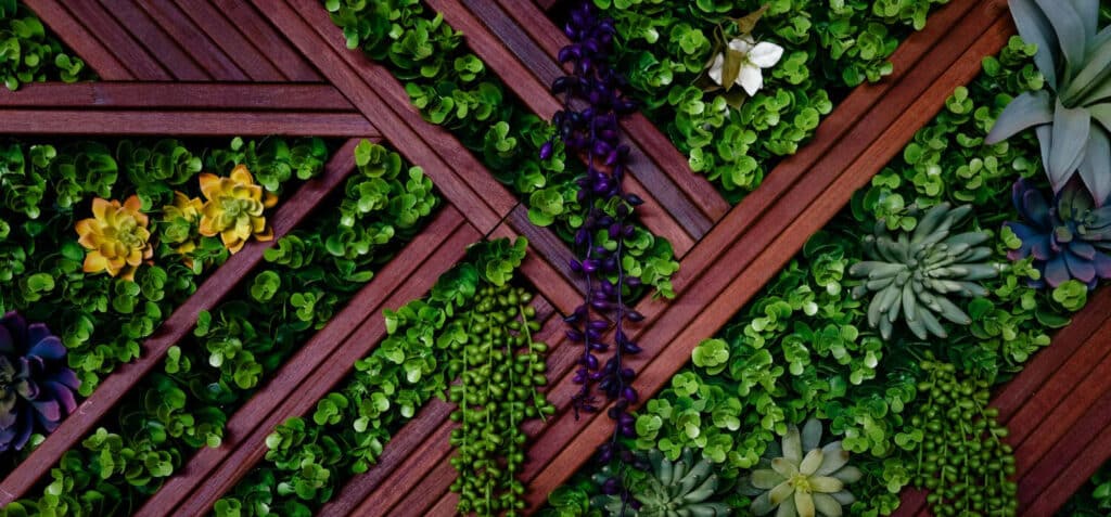 Jardin vertical fait maison avec des palettes en bois, poches de plantation et plantes aromatiques installé sur une terrasse