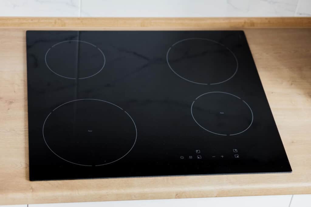 Plaque de cuisson à induction fissurée, illustrant le danger et les faibles possibilités de réparation.