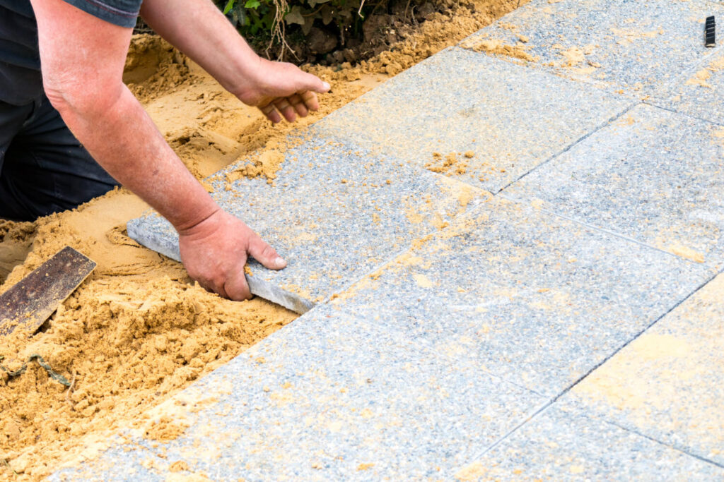 Pose de dalles sur un lit de sable pour une terrasse, montrant les avantages et inconvénients de la technique.