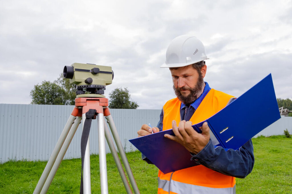 Marge d'erreur sur une limite de propriété : que dit la loi ? 4 géomètre qui délimite un terrain maison