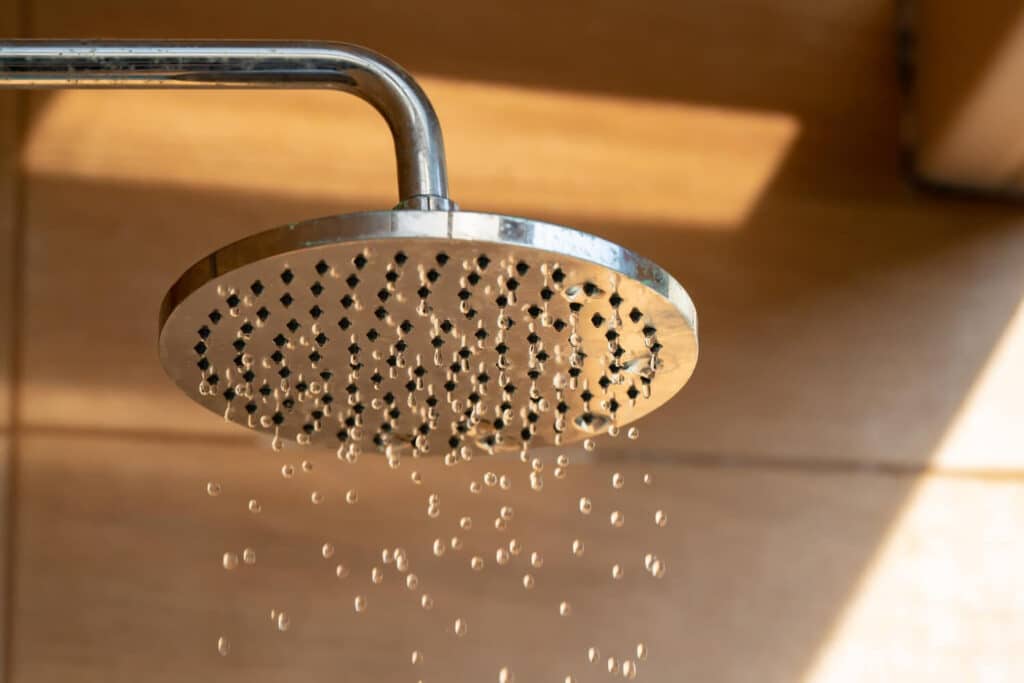 Pommeau de douche qui goutte la nuit, illustrant un problème de robinet mitigeur.