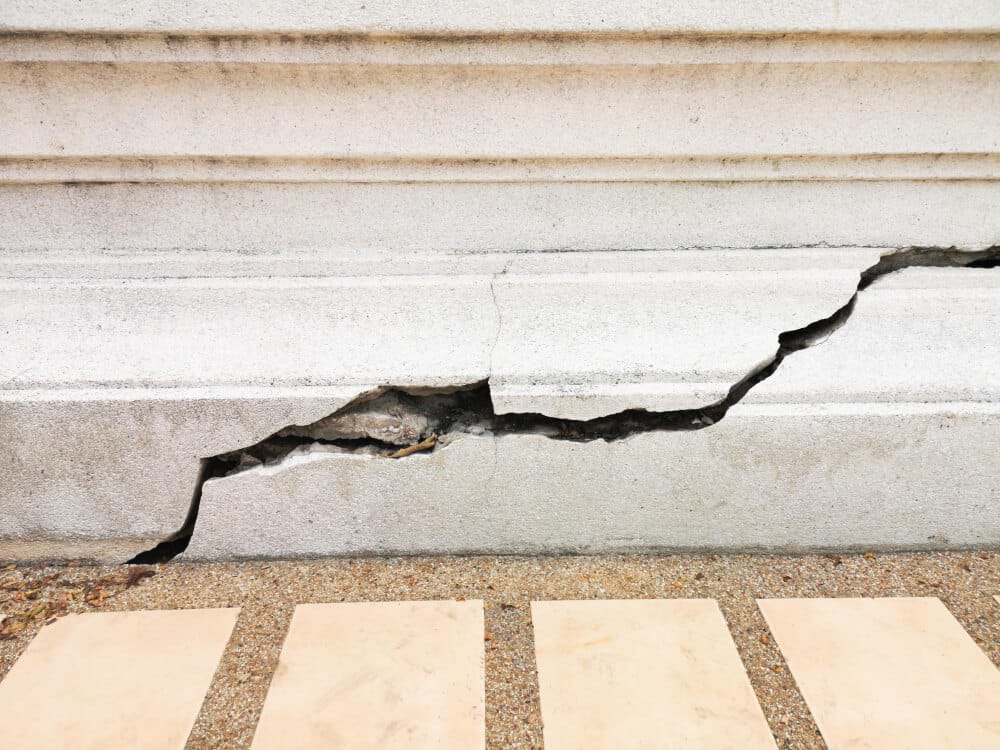 Fissure en escalier dans un mur en parpaing, se demandant si elle est structurelle ou non.