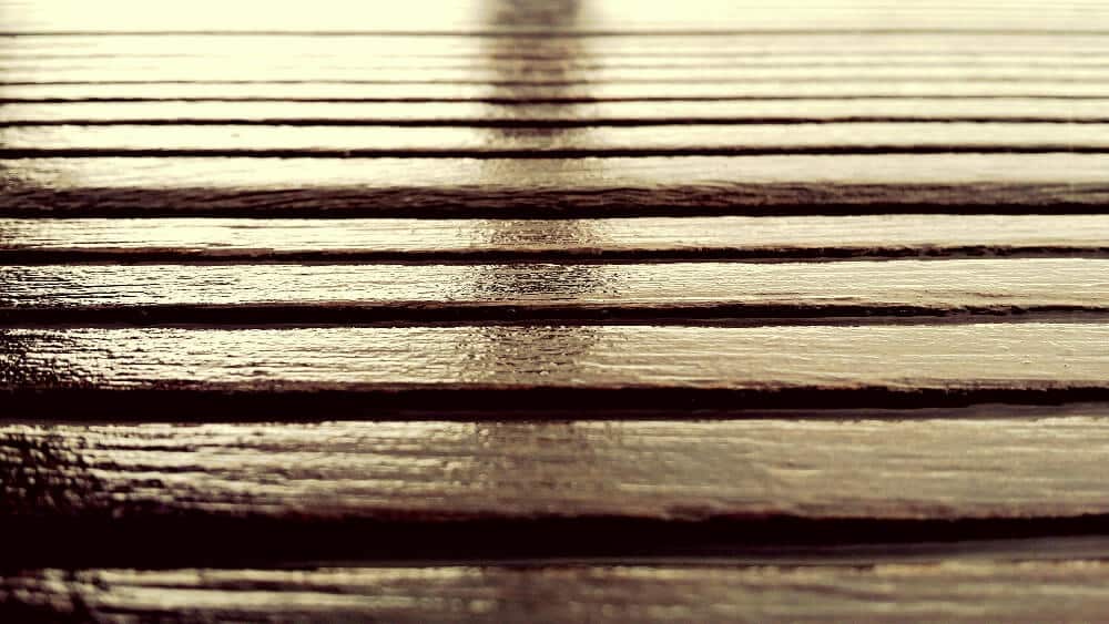 Terrasse en bois avec des traces blanches après une pluie sur un saturateur pas sec.
