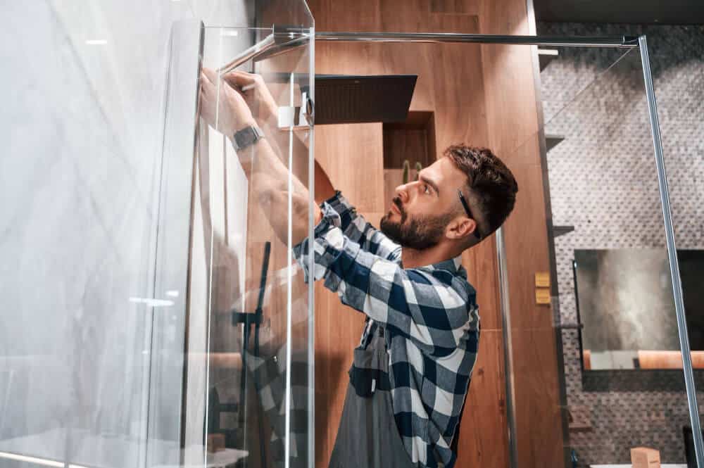 Une paroi de douche en verre trempé entièrement brisée en milliers de petits morceaux.