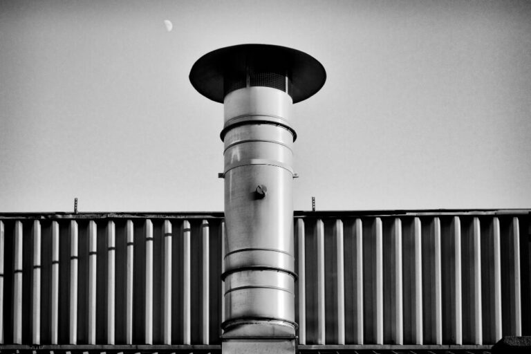 Conduit de cheminée en inox noirci après un feu de conduit, vu de l'intérieur.