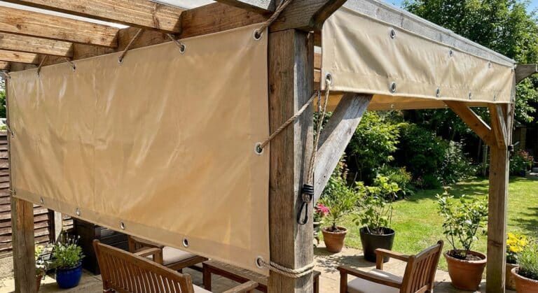 Bâche de pergola sur mesure en PVC haute densité installée sur une structure en bois avec œillets de fixation