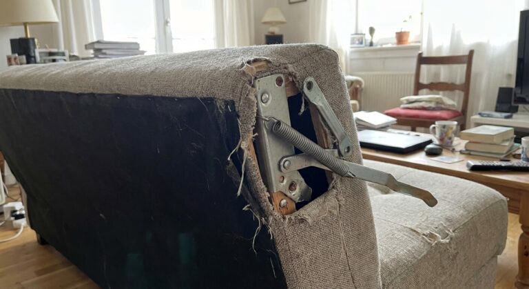 Mécanisme de charnière (compas) déboîté sur le côté d'un canapé convertible de type clic-clac