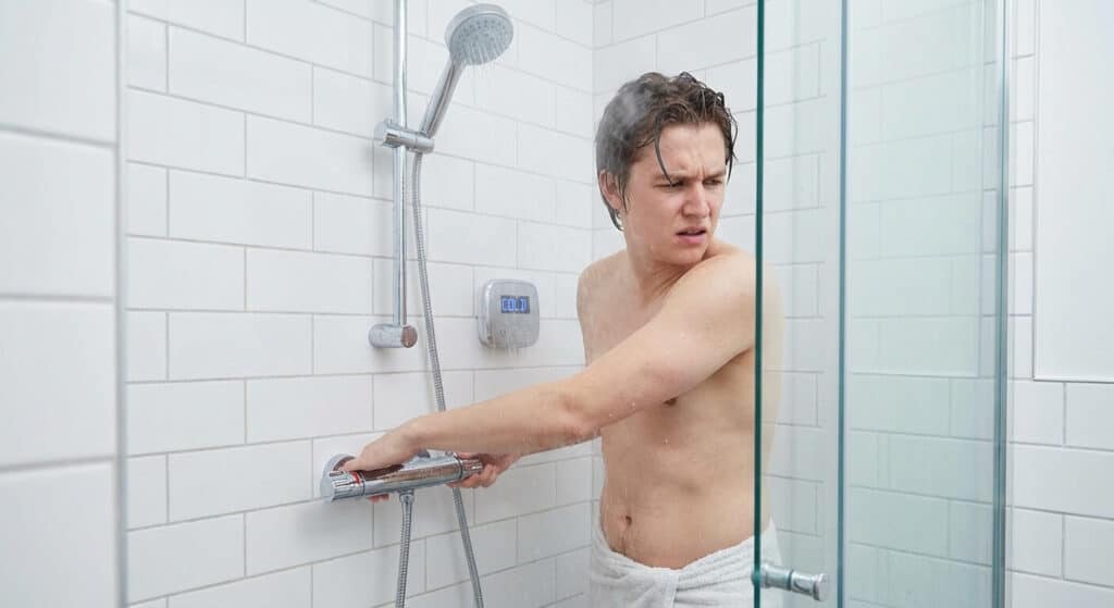 Utilisateur tournant la poignée de réglage de température d'un mitigeur thermostatique de douche sans obtenir d'eau chaude