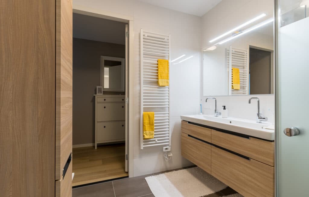 Aménagement optimisé d'un plan de vasque suspendu pour faciliter la circulation dans une salle de bains rénovée.