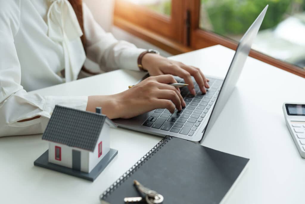 Propriétaire comparant des offres d'assurance habitation sur un ordinateur portable