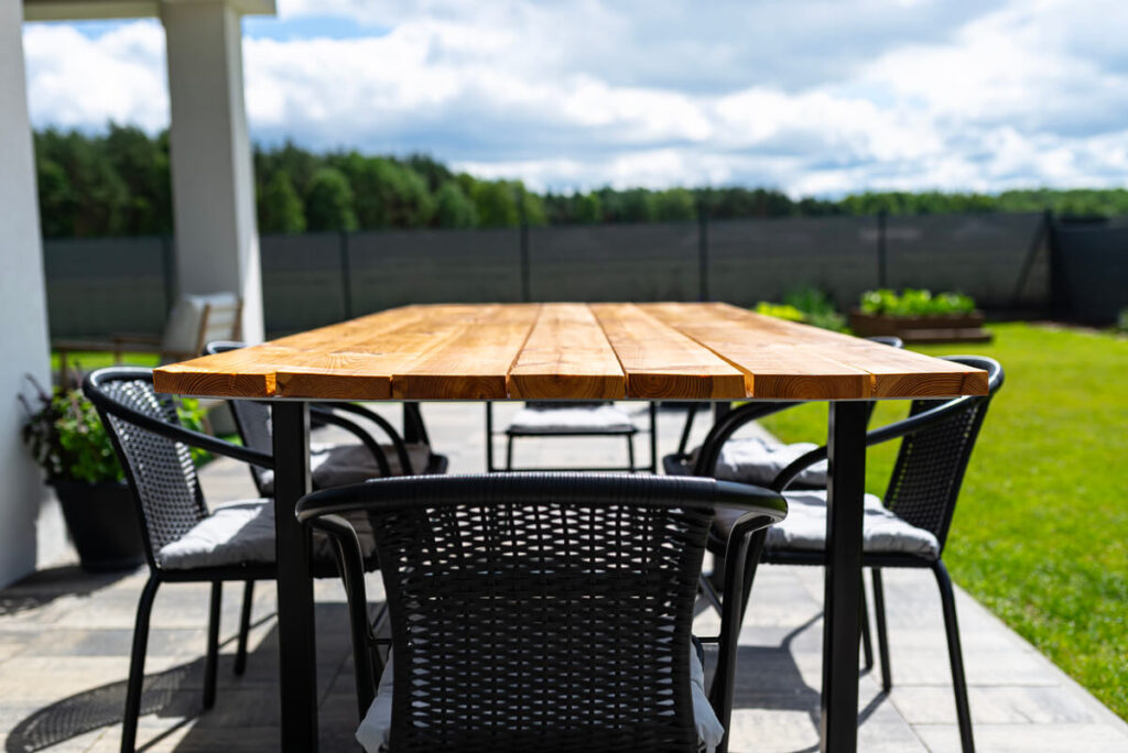 Chaise de jardin avec accoudoirs autour d'une table de repas extérieure en été