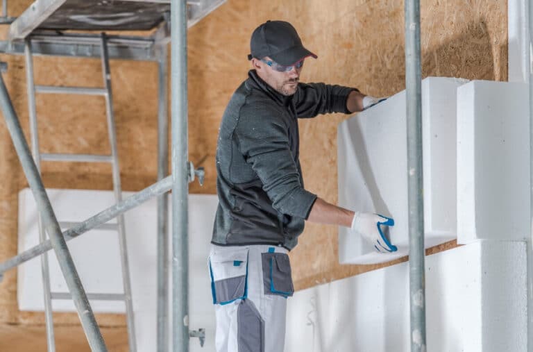 Mise en œuvre de panneaux isolants sur une façade de maison pour améliorer la performance thermique.