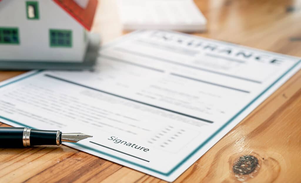 Document de contrat d'assurance habitation avec liste de garanties et stylo