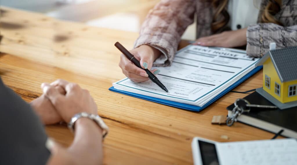 Un propriétaire signant son contrat d'assurance dommages ouvrage pour sécuriser son chantier de construction.