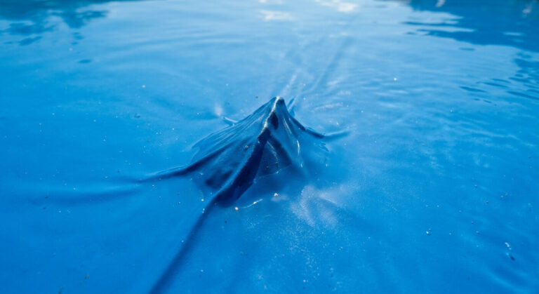 Accueil 2 Déformation pointue visible sur le fond en PVC d'une piscine provoquée par un gravier oublié.