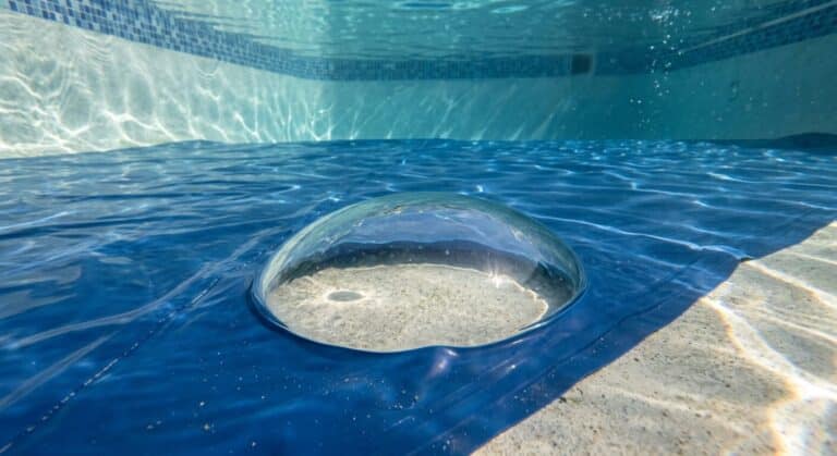 Une cloque ou une bulle d'eau formée sous le liner en PVC au fond d'un bassin de piscine.