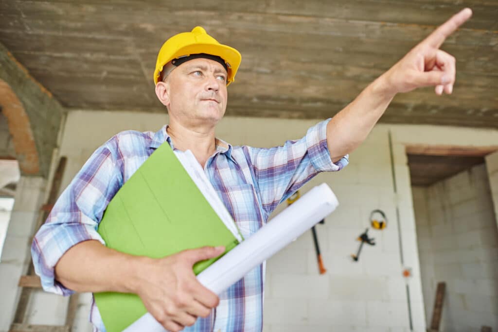 Entreprise d'isolation : comment choisir le bon professionnel pour ses travaux ? 3 Un artisan du bâtiment présentant ses certifications et assurances obligatoires avant de signer un devis d'isolation.