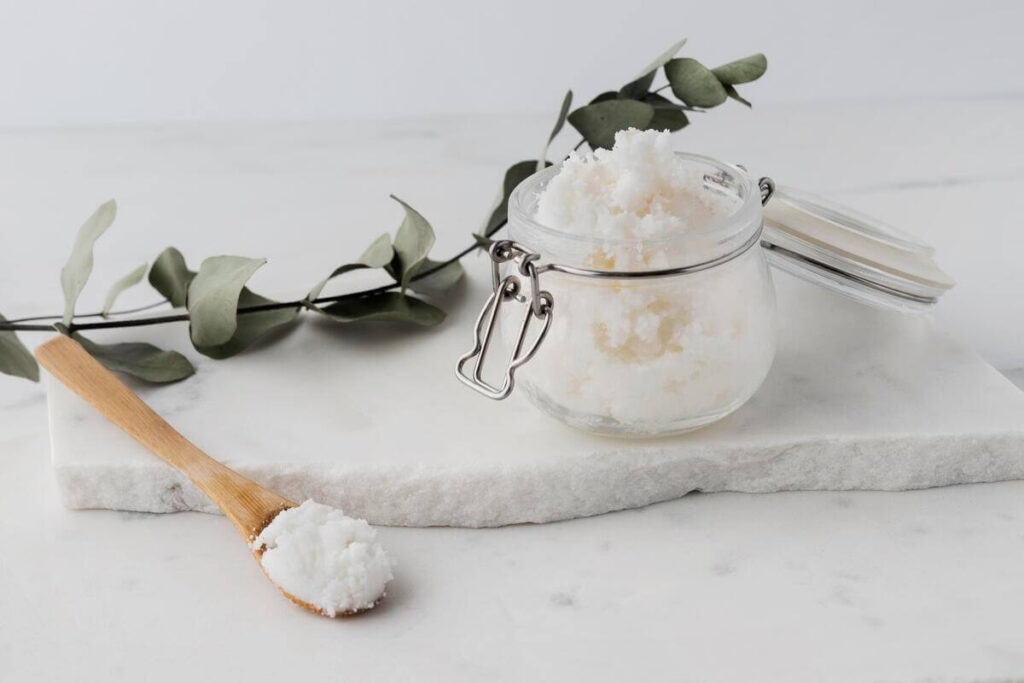De la poudre fine de blanc de Meudon dans un bocal en verre avec une cuillère en bois pour le ménage écologique.