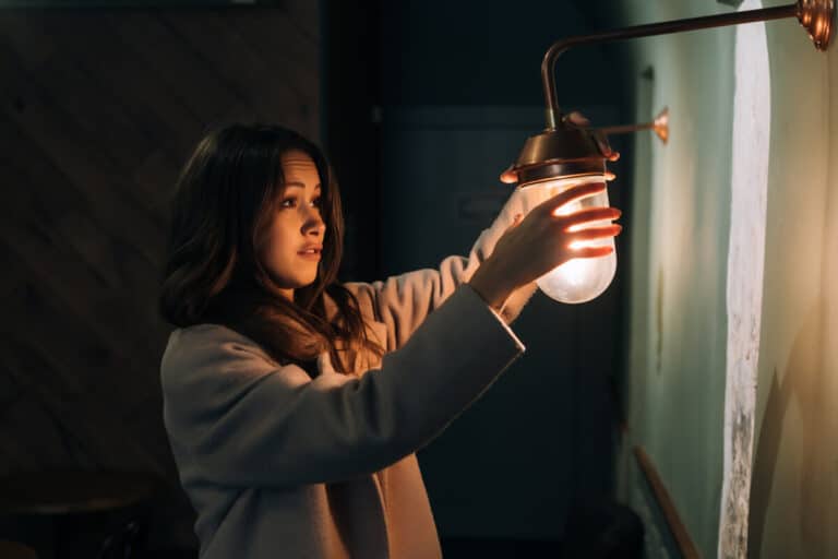 Accueil 1 Une ampoule dans une pièce sombre s'éteignant mystérieusement.