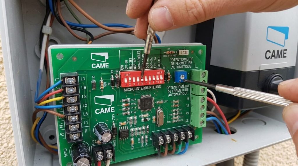 Carte électronique de commande CAME avec réglage des micro-interrupteurs DIP-switch et du potentiomètre de fermeture automatique.