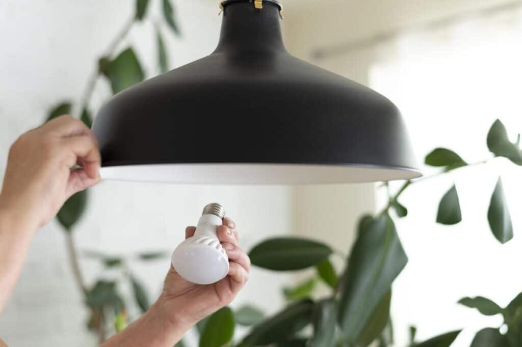 Ampoule LED de plafonnier clignotant de façon irrégulière dans une pièce de vie.