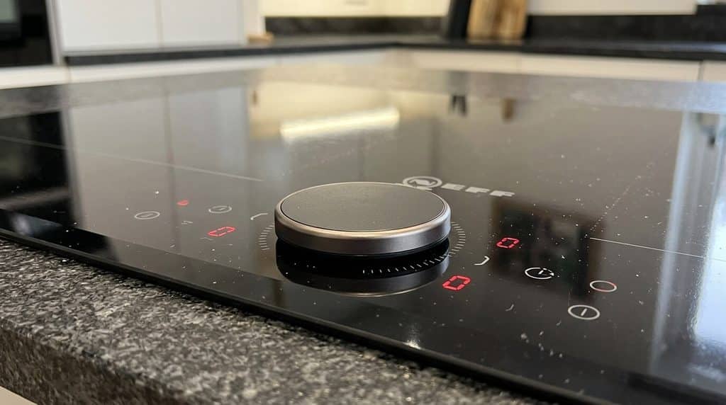 Déverrouiller une plaque Neff : la manipulation selon votre modèle 3 Bouton rotatif amovible TwistPad posé sur la table de cuisson à induction Neff.